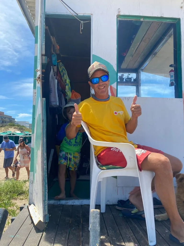 El guardavidas en el puesto de la playa con los pulgares arriba